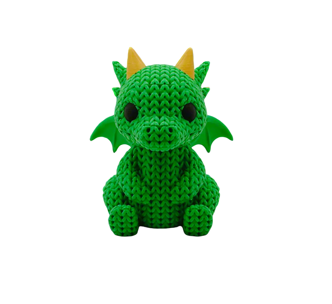 Green crochet dragon toy with yellow horns on a white background